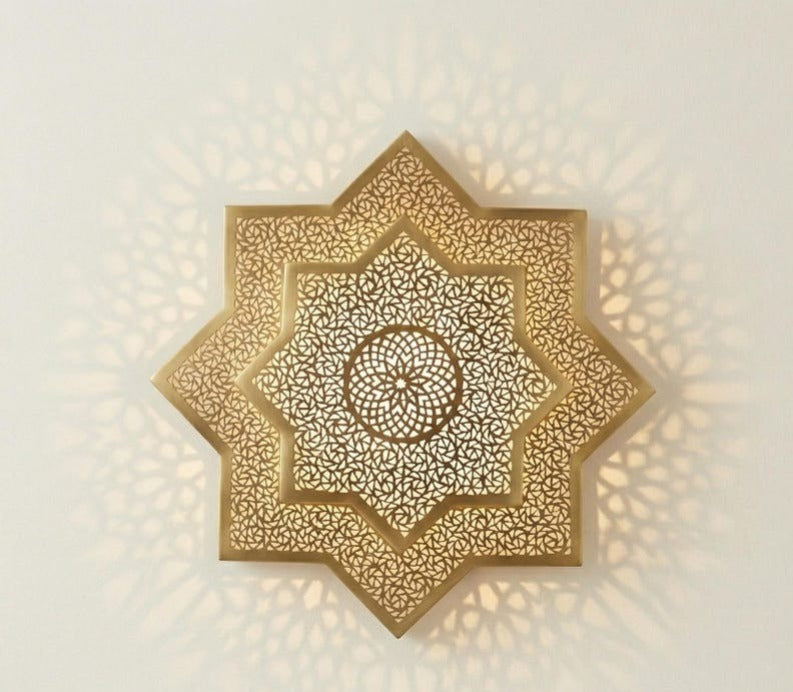 Handmade Moroccan Brass Star Wall Sconce – Pierced Eight-Point Geometric Wall Light with Warm Golden Glow and Dramatic Sunburst Shadow Patterns
